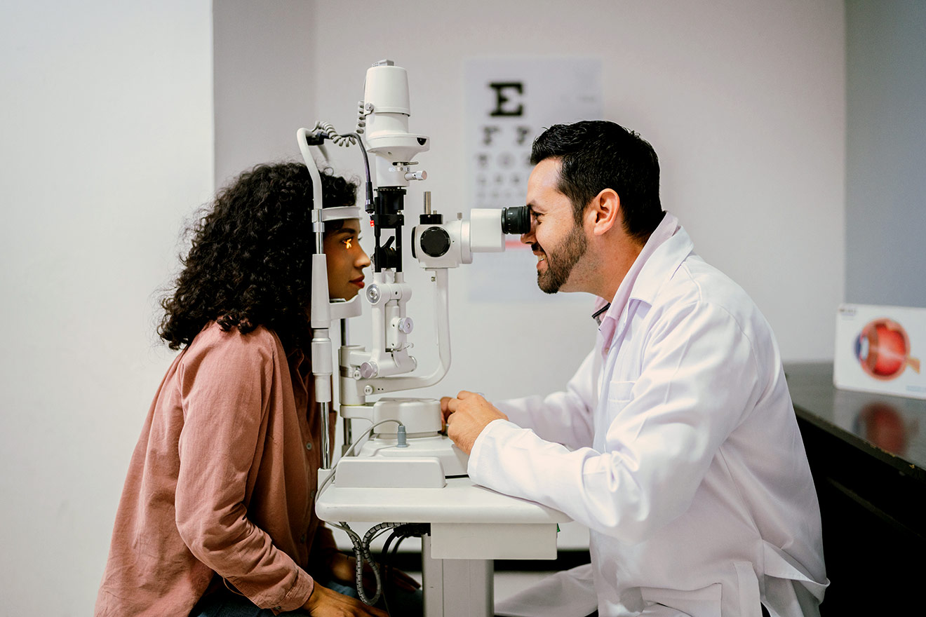 Médico oftalmologista examinando paciente na lâmpada de fenda